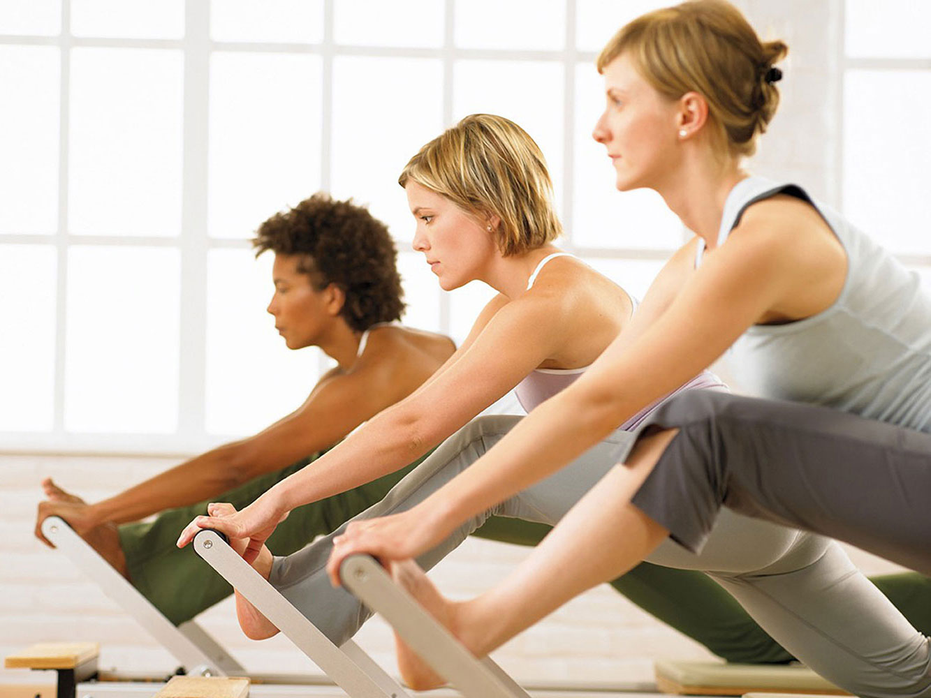 Pilates group of three individuals with equipment, in training, Instructor Training Courses and CECs