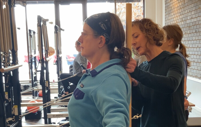 Pilates Loft instructor, working with student client on apparatus
