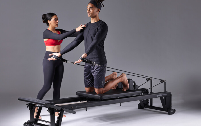 Getting Started With Pilates, instructor guides student on reformer equipment