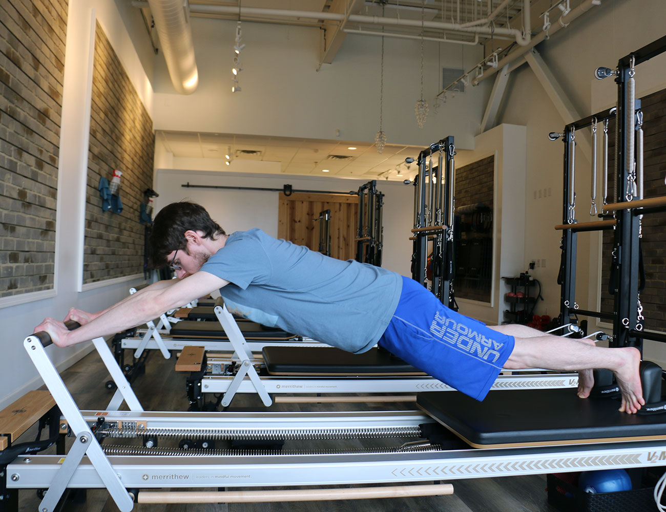 strength reformer, pilates reformer, man demonstrating reformer pilates