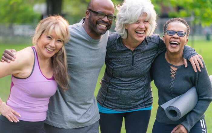 Pilates longevity connection, group of four adults outdoors, athletic clothing, smiling